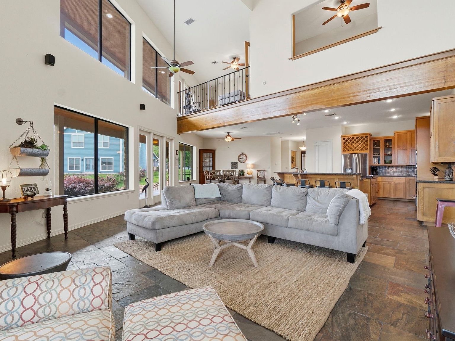 The kitchen at 295 Bayview Lane with stained wood cabinetry, granite counters, central island with seating, and a window framing the lake beyond